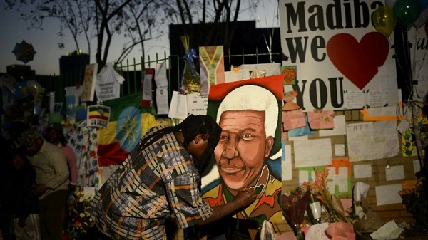 Một người đàn ông Nam Phi vẽ chân dung ông Nelson Mandela bên ngoài bệnh viện nơi ông đang được điều trị - Ảnh: Reuters