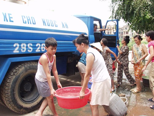 Người dân Hà Nội đi lấy nước ăn từ xe bồn trở tới. Ảnh: Hồng Vĩnh.