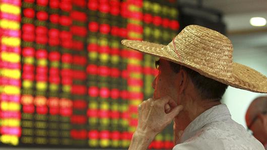 Nhà đầu tư quan sát giá chứng khoán tại Hải Khẩu, Trung Quốc 11/8/2015 Ảnh: Reuters