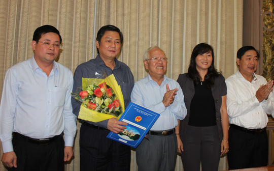 Ông Đào Anh Kiệt, Giám đốc Sở Tài nguyên Môi trường TP (cầm hoa) nhận quyết định thôi giữ chức vụ (Ảnh: Ph.Anh)