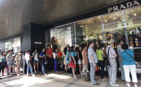 
Khách hàng Đại Lục, bộ phận chiếm 1/3 tổng doanh thu của hãng Gucci và Prada, đang xếp hàng mua hàng cao cấp tại Tsim Sha Tsui, Hong Kong trong bộ ảnh năm 2014. Ảnh: David Wong.
