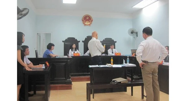 Ảnh: thử nghiệm mở chai, cho vật lạ và đóng lại bằng tay của đại diện Coca-Cola Việt Nam tại phiên tòa sáng 15/9 (báo Gia đình - Xã hội).