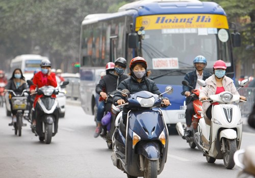 Phần lớn người đi xe máy, xe đạp đeo khẩu trang khi ra đường (Ảnh chụp trên đường Minh Khai, Hà Nội chiều 3/3). Ảnh: Như Ý
