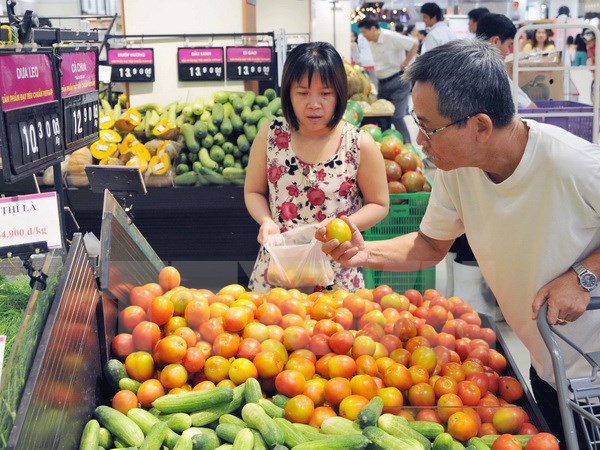 Khách hàng ở Thành phố Hồ Chí Minh chọn mua các mặt hàng rau củ quả bày bán tại Trung tâm mua sắm AEON MALL. (Ảnh: An Hiếu/TTXVN)