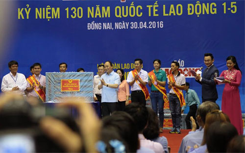 Thủ tướng Nguyễn Xuân Phúc tặng quà cho đại diện công nhân tại các khu công nghiệp - Ảnh: Mỹ An.