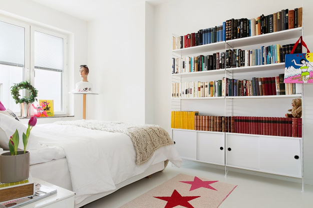 Điểm nhấn của không gian nghỉ ngơi được tạo nên bởi tấm thảm nhỏ xinh trải sàn, gối nằm, đèn ngủ, chậu cây xanh và vô vàn những cuốn sách trên kệ.