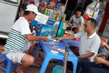 
“Cò” Toàn (phải) đang chơi bài trong khi chờ khách tại quán nước cạnh Chi cục Thuế quận Cầu Giấy. 
