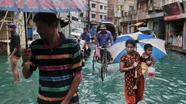 Người dân Bangladesh đi qua một con đường ngập nước do bão - Ảnh: AP