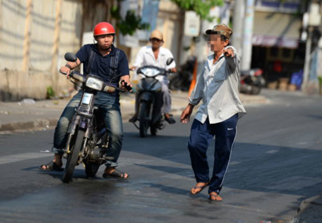 
Một “cò” (đội nón lưỡi trai) chèo kéo người dân đi khám bệnh trước Bệnh viện Da liễu (đường Nguyễn Thông, P.6, Q.3, TP.HCM) - Ảnh: Hữu Khoa
