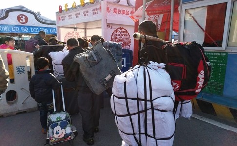 Anh Luo Cheng, một công nhân đang gồng gánh hành lý để về quê ở Hồ Nam