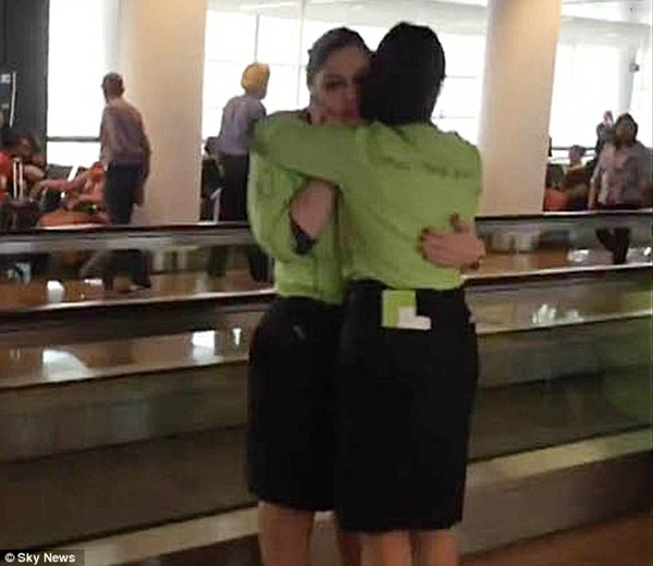 
Hai nhân viên sân bay vui mừng ôm lấy sau khi thoát nạn.
