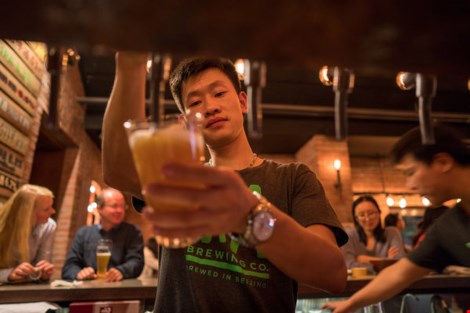 Khách hàng hứng thú tự rót bia tại nhà hàng Jing-A Brewing. (Ảnh: NEW YORK TIMES) 