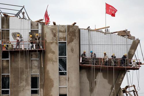 
Các công nhân đang xây dựng một tòa nhà cao tầng ở trung tâm Bình Nhưỡng.
