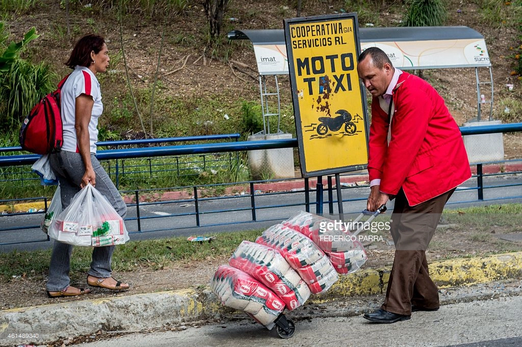 
Một người dân Venezuela đã mua được khá nhiều đồ ăn sẵn tại siêu thị. Anh phải dùng một chiếc xe kéo để đẩy về nhà. Ảnh: FEDERICO PARRA/ Stringer
