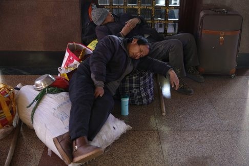 Công nhân ngủ gật chờ chuyến tàu của mình tại nhà ga Foshan