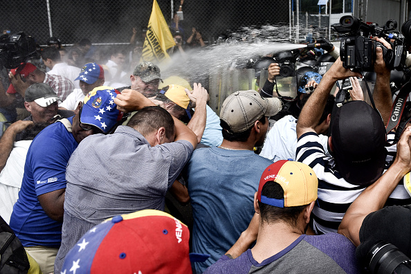 
Cảnh sát chống bạo động sử dụng hơi cay để giải tán đám đông biểu tình. Tình trạng khốn cùng của người dân được phe đối lập tận dụng nhằm phát động các cuộc tuần hành chống chính phủ, kêu gọi trưng cầu dân ý lật đổ Tổng thống Maduro. Ảnh: Getty
