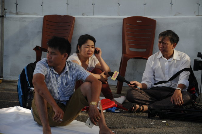 Một nhóm người thân thức trắng suốt đêm ở càng sông Hàn chờ tìn người thân từ lực lượng cứu nạn - Ảnh: ĐĂNG NAM