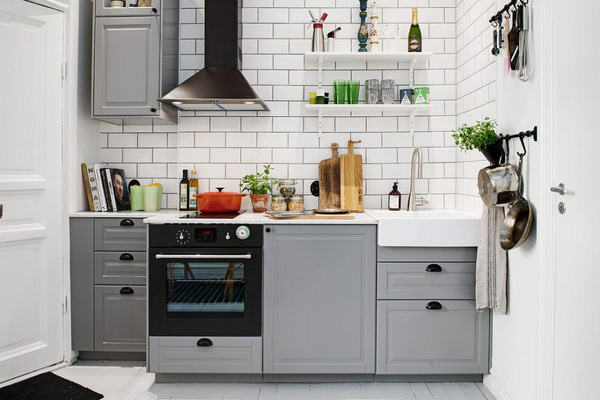 Nhà bếp sạch sẽ với tủ bếp chữ I màu xám và đá ốp tường trắng dễ dàng cho việc lau chùi.