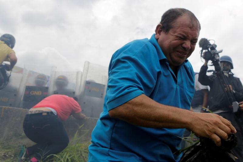 
Người biểu tình bỏ chạy vì lựu đạn hơi cay. Henrique Capriles, lãnh đạo phe đối lập, khẳng định, họ sẽ không bỏ cuộc. Ảnh: Reuters
