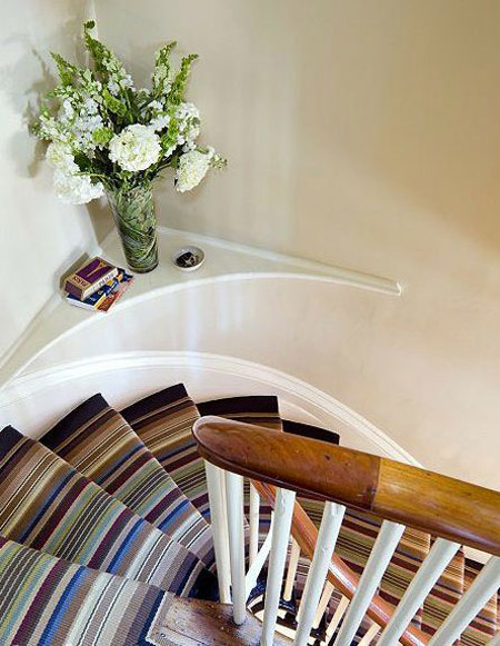 Những bậc cầu thang sẽ thêm tinh tế khi có sự xuất hiện của một lọ hoa với sắc màu tươi tắn, nhã nhặn đặt ở góc cầu thang.