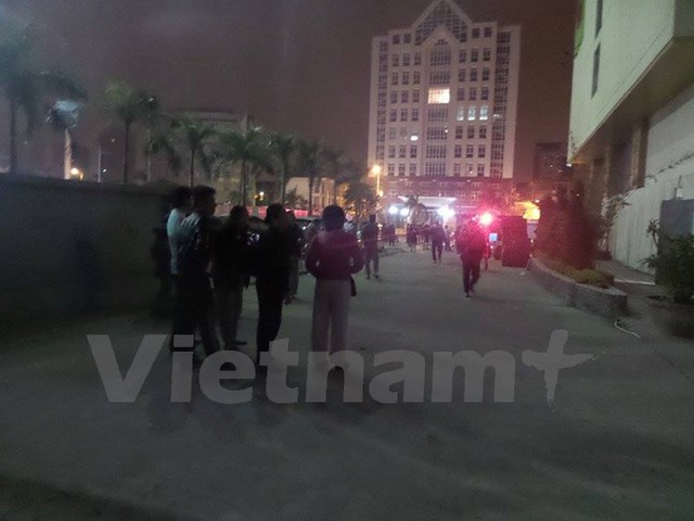 Người dân hốt hoảng chạy xuống sân dưới vì lo sợ khói và lửa có thể lan ra (Ảnh: PV/Vietnam+)