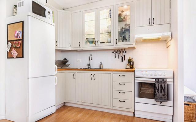 
Nhà bếp được thiết kế đơn giản nhưng sang trọng, sự kết hợp màu trắng với điểm nhấn từ tông màu gỗ tự nhiên là cách lựa chọn hài hòa, đẹp mắt. Cách sắp xếp khu vực này cũng khá thông minh. Chủ nhân đã đặt chiếc lò vi sóng lên trên đầu tủ lạnh để tiết kiệm
