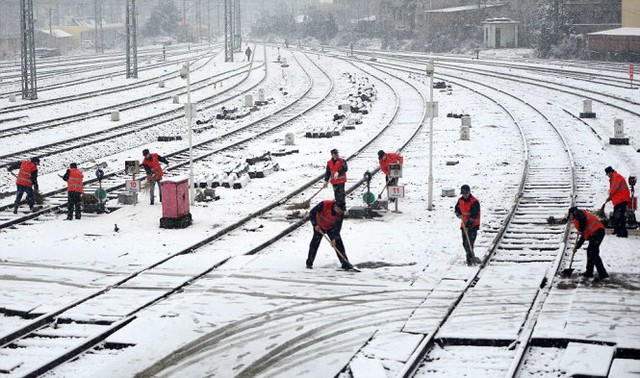 
Công nhân dọn tuyết trên đường ray bên ngoài một nhà ga xe lửa ở Nam Xương, tỉnh Giang Tây - Ảnh: Reuters
