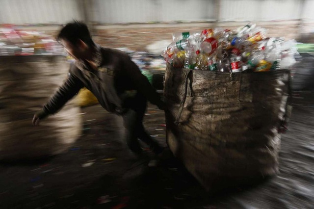 Một công nhân đang thu gom chai lọ tại 1 cơ sở thu mua, tái chế nhựa ở Bắc Kinh, Trung Quốc.