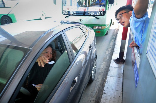 
Một tài xế thắc mắc về mức phí khi qua trạm thu phí cầu Đồng Nai trưa 1-1-2016 - Ảnh: A Lộc
