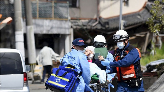 
Một nạn nhân cao tuổi được nhân viên cứu hộ đưa ra khỏi nơi nguy hiểm - Ảnh: Reuters
