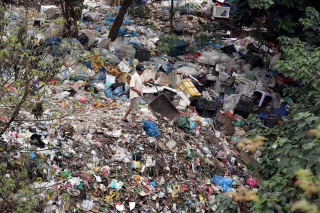 Một người dân đi đổ rác tại bãi rác ở Hà Nội, Việt Nam.