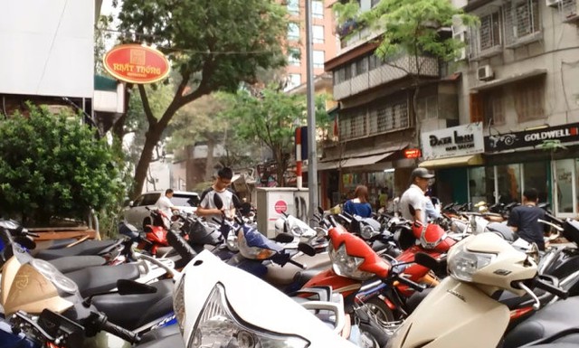 Một bãi xe tự phát mọc lên trước sảnh Ngân hàng Nhà nước thu với giá 10.000 đồng/lần gửi - Ảnh: Quang Thế