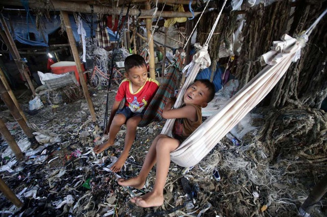 2 cậu bé người Indonesia đang ngồi chơi ở 1 khu vực ô nhiễm trong khu ổ chuột tại Jakarta.