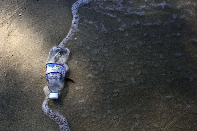 Một chai nước nằm trên bãi cát ở bờ biển Monkey (Telak Duyung), bên trong Công viên quốc gia Penang, Malaysia.