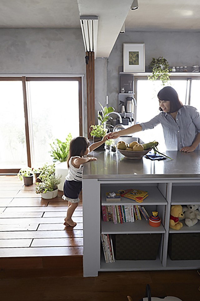 Đảo bếp kết hợp làm tủ để sách và ngăn cách khu nấu nướng với các không gian khác.