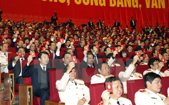 Các đại biểu biểu quyết thông qua Nghị quyết Đại hội XII Đảng Cộng sản Việt Nam. (Ảnh: TTXVN)