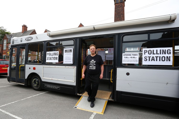 
Người dân rời địa điểm bỏ phiếu tạm thời được đặt trên một chiếc xe buýt. Ảnh: Getty Images
