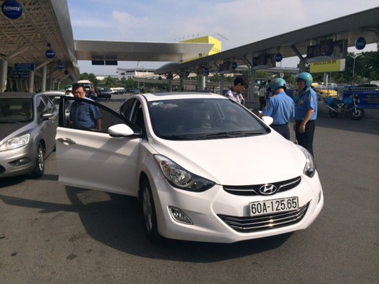 Lực lượng chức năng kiểm tra một taxi Uber tại TP HCM Ảnh: THU HỒNG