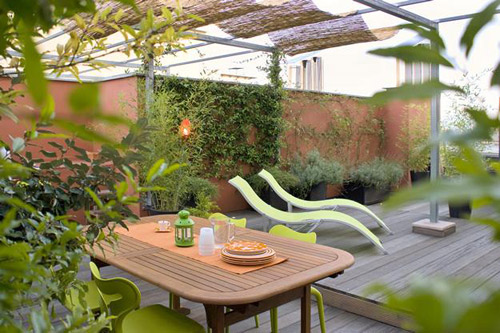 Với sàn gỗ, cây xanh và bàn ghế tông màu nâu xanh như thế này, sân thượng nhà bạn sẽ thổi bay cái nắng nóng mùa hè giữa lòng thành phố.