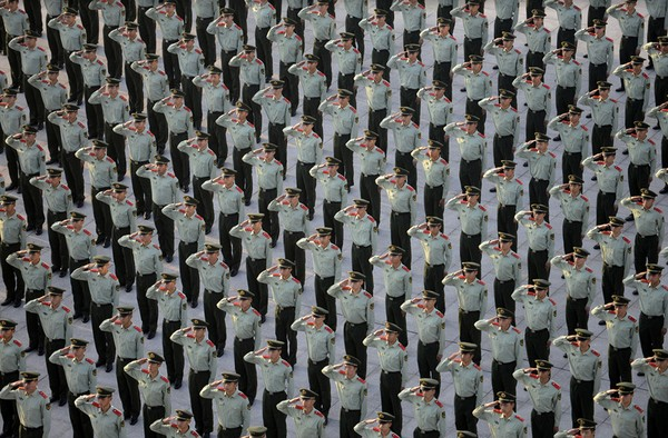Lực lượng cảnh sát quân sự đang giơ tay chào trong 1 lễ chào cờ chào mừng ngày kỷ niệm 65 năm Quốc khánh nước Cộng hòa Nhân dân Trung Hoa. Ảnh chụp tại Giang Tô, Trung Quốc vào ngày 1/10/2014.