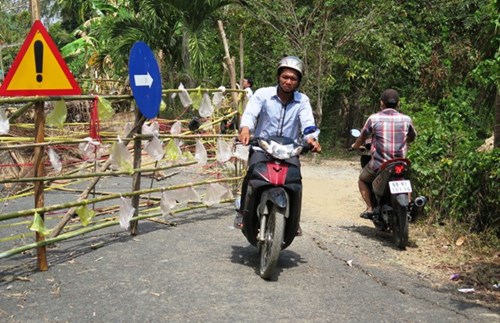 
Người dân đi bằng xe máy, xe thô sơ bằng con đường tạm vừa mở.
