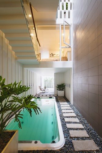 Tầng 1 được bố trí bể bơi và cây xanh khiến không gian ngôi nhà trở nên dịu mát.