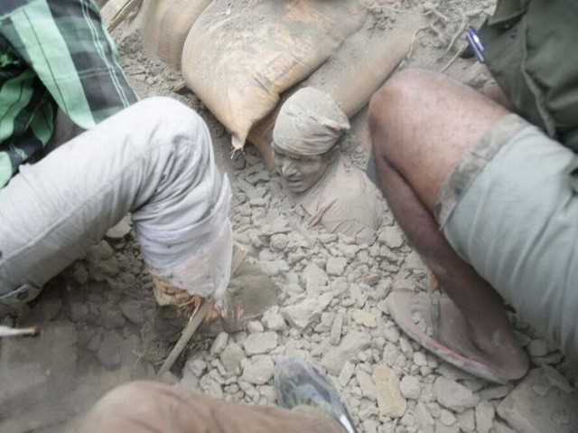 Người đàn ông  Nepal bị chôn vùi trong đống đổ nát tòa nhà đang chờ được cứu ở Kathmandu - Ảnh: EPA
