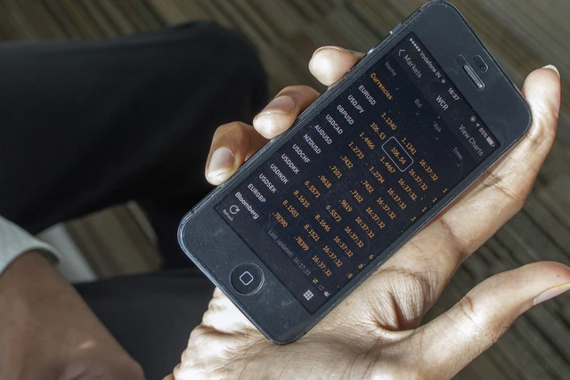 
Agrawal dùng phần mềm trên điện thoại di động để nghe tỷ giá hối đoái. Ảnh: Prashanth Vishwanathan/Bloomberg
