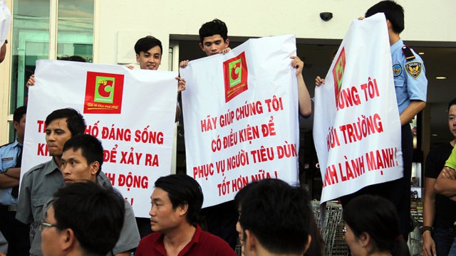 Nhân viên BigC đưa băng rôn biểu ngữ đề nghị TP Đà Nẵng can thiệp giải quyết các hành động cản trở kinh doanh tại tòa nhà Vĩnh Trung - Ảnh: TRƯỜNG TRUNG.