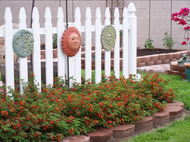 Bức tường rào quét sơn trắng cùng những mặt nạ hình mặt trời ngộ nghĩnh thế này sẽ tạo điểm nhấn cho ngôi nhà bạn.