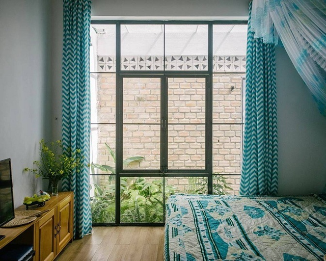 Phòng ngủ của 2 vợ chồng khá mát mẻ với cửa sổ lớn bằng kính nhìn ra khu vườn, thiết kế nhẹ nhàng với tông màu tinh tế.
